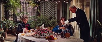 Movie still from “Gigi” (1958), directed by Vincente Minnelli – A man and a woman sitting at a dinner table; Medium shot, Over the shoulder angle