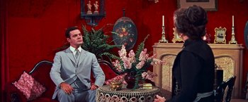 Movie still from “Gigi” (1958), directed by Vincente Minnelli – A man sitting at a table in front of a vase of flowers; Medium shot, Over the shoulder angle