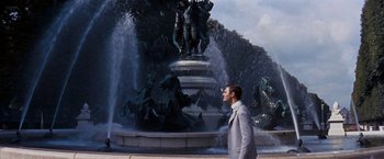 Movie still from “Gigi” (1958), directed by Vincente Minnelli – A man standing in front of a fountain; Wide shot, High angle