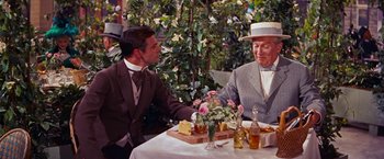 Movie still from “Gigi” (1958), directed by Vincente Minnelli – A man and a woman sitting at an outdoor table; Medium shot, Over the shoulder angle