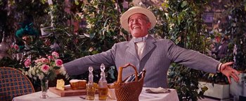 Movie still from “Gigi” (1958), directed by Vincente Minnelli – An older man sitting at a table with a hat on; Medium shot, Low angle