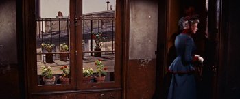 Movie still from “Gigi” (1958), directed by Vincente Minnelli – A view of a balcony through a window of a house; Medium shot, Over the shoulder angle