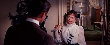 Movie still from “Gigi” (1958), directed by Vincente Minnelli – A man and a woman looking in the same direction in the mirror; Medium shot, Over the shoulder angle