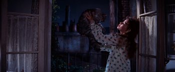 Movie still from “Gigi” (1958), directed by Vincente Minnelli – A girl holding a cat up to her face; Medium shot, Low angle