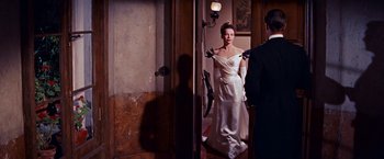 Movie still from “Gigi” (1958), directed by Vincente Minnelli – A woman in a white dress standing in front of a mirror; Medium shot, Over the shoulder angle