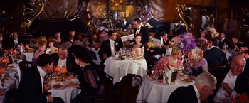 Movie still from “Gigi” (1958), directed by Vincente Minnelli – A group of people sitting at tables in a restaurant; Wide shot, High angle