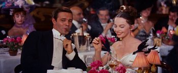 Movie still from “Gigi” (1958), directed by Vincente Minnelli – A man and a woman sitting at a dinner table; Medium shot, Low angle