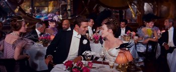 Movie still from “Gigi” (1958), directed by Vincente Minnelli – A man and a woman sitting at a dinner table; Medium shot, Over the shoulder angle