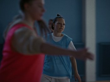 Movie still from “Girl Picture” (2022), directed by Alli Haapasalo – A group of young people playing a game of basketball; Medium shot, Over the shoulder angle