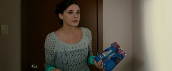 Movie still from “Girl House” (2014), directed by Trevor Matthews – A woman is holding something in her hands; Close Up shot, Over the shoulder angle