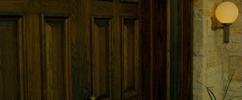 Movie still from “Girl House” (2014), directed by Trevor Matthews – A wooden door that has been stained dark; Extreme Close Up shot, High angle