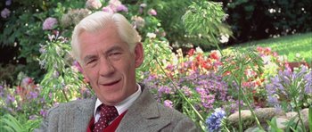 Movie still from “Gods and Monsters” (1998), directed by Bill Condon – An older man in a suit and tie in a flower garden; Close Up shot, Low angle