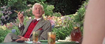 Movie still from “Gods and Monsters” (1998), directed by Bill Condon – An older man sitting at a table in a garden; Medium shot, Low angle