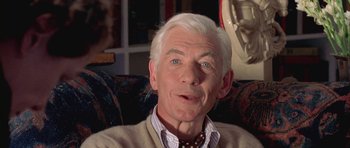 Movie still from “Gods and Monsters” (1998), directed by Bill Condon – An older man sitting in a chair with a smile on his face; Close Up shot, Low angle