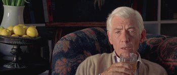 Movie still from “Gods and Monsters” (1998), directed by Bill Condon – An older man sitting in a chair holding a glass; Close Up shot, Over the shoulder angle