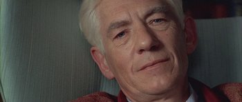 Movie still from “Gods and Monsters” (1998), directed by Bill Condon – An older man with white hair and blue eyes looking at the camera; Close Up shot, High angle