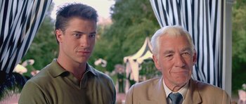 Movie still from “Gods and Monsters” (1998), directed by Bill Condon – A man and a man standing next to each other in front of trees; Close Up shot, Low angle