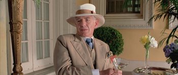 Movie still from “Gods and Monsters” (1998), directed by Bill Condon – An older man wearing a suit and hat holding a martini glass; Close Up shot, Low angle