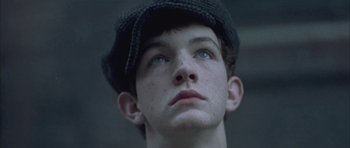 Movie still from “Gods and Monsters” (1998), directed by Bill Condon – A young boy wearing a hat looking upward; Close Up shot, Low angle