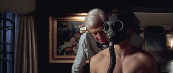Movie still from “Gods and Monsters” (1998), directed by Bill Condon – An older man is adjusting a gas mask on a young man's face; Close Up shot, Over the shoulder angle