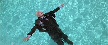 Movie still from “Gods and Monsters” (1998), directed by Bill Condon – A man in a suit floating in a pool of water; Medium shot, Overhead angle