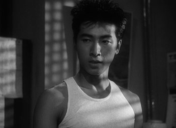 Movie still from “Godzilla” (1954), directed by Ishirô Honda – Black and white photograph of a young man in a tank top; Close Up shot, Low angle