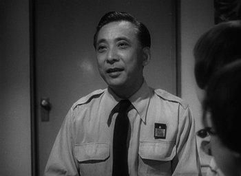 Movie still from “Godzilla” (1954), directed by Ishirô Honda – A man in a uniform is smiling for the camera; Close Up shot, Low angle