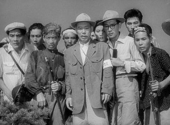 Movie still from “Godzilla” (1954), directed by Ishirô Honda – A group of people standing next to each other; Medium shot, High angle