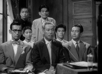 Movie still from “Godzilla” (1954), directed by Ishirô Honda – A black and white photo of a group of people; Medium shot, Low angle