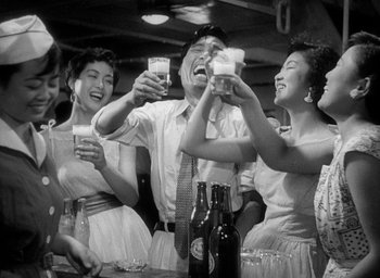 Movie still from “Godzilla” (1954), directed by Ishirô Honda – A group of people are drinking beer at a party; Medium shot, Low angle