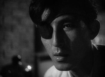 Movie still from “Godzilla” (1954), directed by Ishirô Honda – A black - and - white photo of a young man's face; Close Up shot, Over the shoulder angle