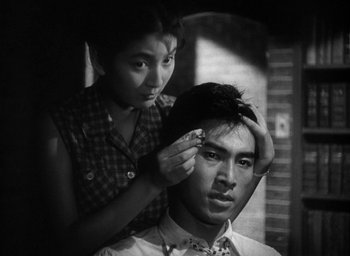 Movie still from “Godzilla” (1954), directed by Ishirô Honda – A man getting his hair combed by a woman; Close Up shot, Low angle