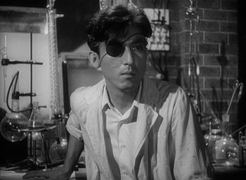 Movie still from “Godzilla” (1954), directed by Ishirô Honda – A young man wearing a eye patch in a room; Close Up shot, Low angle