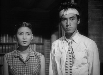 Movie still from “Godzilla” (1954), directed by Ishirô Honda – A man and a woman standing next to each other; Medium shot, Low angle