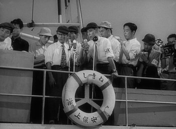 Movie still from “Godzilla” (1954), directed by Ishirô Honda – A black and white photo of a group of men on a boat; Medium shot, High angle