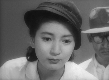 Movie still from “Godzilla” (1954), directed by Ishirô Honda – A young woman wearing a hat and looking at the camera; Close Up shot, High angle