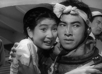 Movie still from “Godzilla” (1954), directed by Ishirô Honda – A man and a woman pose for a picture; Close Up shot, High angle
