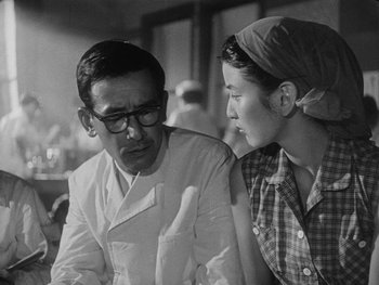 Movie still from “Godzilla: King of the Monsters!” (1956), directed by Ishirô Honda – An old photo of a man and a woman; Close Up shot, Over the shoulder angle