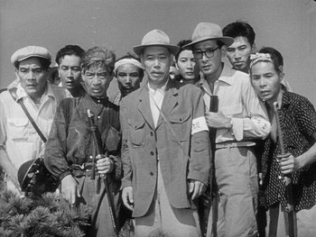 Movie still from “Godzilla: King of the Monsters!” (1956), directed by Ishirô Honda – A group of men standing next to each other in a field; Medium shot, High angle
