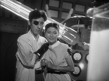 Movie still from “Godzilla: King of the Monsters!” (1956), directed by Ishirô Honda – A man and a woman are posing for a picture; Medium shot, Low angle