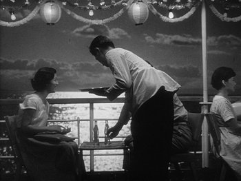 Movie still from “Godzilla: King of the Monsters!” (1956), directed by Ishirô Honda – A man and a woman standing at a table; Medium shot, Low angle