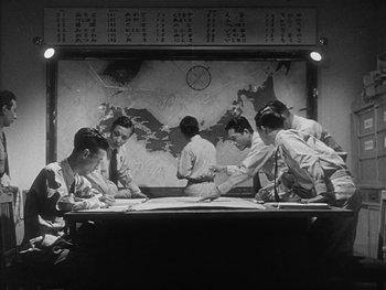 Movie still from “Godzilla: King of the Monsters!” (1956), directed by Ishirô Honda – A group of men sitting at a table with papers; Medium shot, High angle