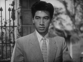 Movie still from “Godzilla: King of the Monsters!” (1956), directed by Ishirô Honda – Black and white photograph of a man wearing a suit and tie; Close Up shot, Low angle