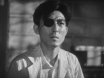 Movie still from “Godzilla: King of the Monsters!” (1956), directed by Ishirô Honda – A man with a eye patch on his face; Close Up shot, Low angle