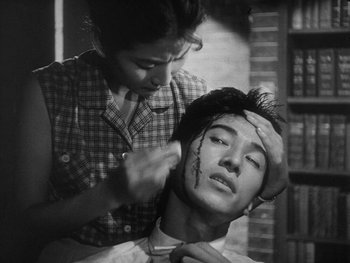 Movie still from “Godzilla: King of the Monsters!” (1956), directed by Ishirô Honda – An old photo of a woman fixing a man's hair; Close Up shot, Low angle