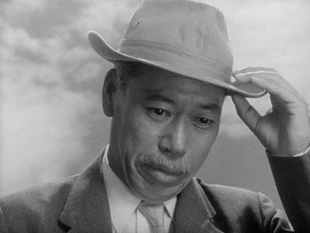 Movie still from “Godzilla: King of the Monsters!” (1956), directed by Ishirô Honda – An older man wearing a suit and a hat; Close Up shot, Low angle