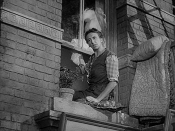 Movie still from “Going My Way” (1944), directed by Leo McCarey – An old photo of a woman sitting on a window ledge; Medium shot, Low angle