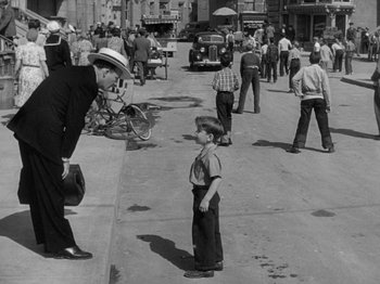 Movie still from “Going My Way” (1944), directed by Leo McCarey – An old black and white photo of a man and a boy; Wide shot, High angle