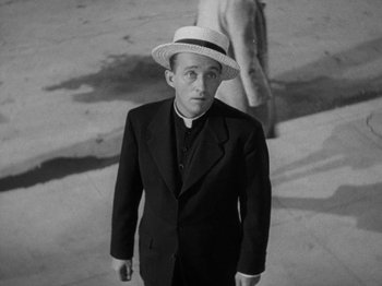 Movie still from “Going My Way” (1944), directed by Leo McCarey – A black and white photo of a man wearing a suit and a hat; Medium shot, High angle