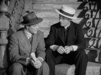 Movie still from “Going My Way” (1944), directed by Leo McCarey – A couple of men sitting next to each other on some steps; Medium shot, Low angle